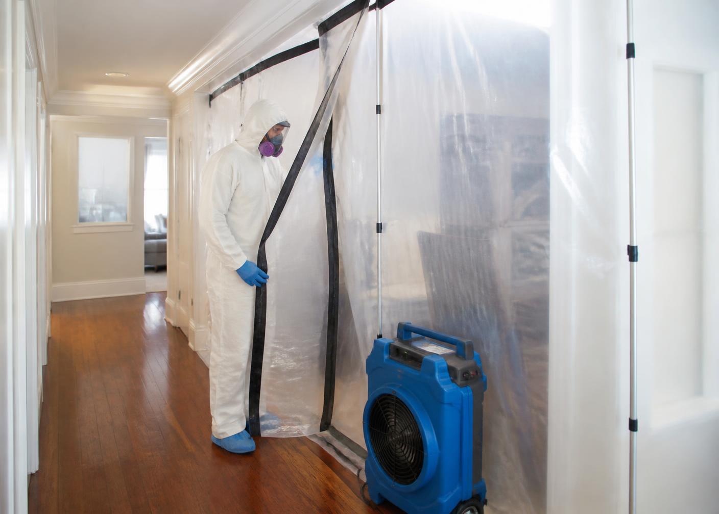 Containment barrier and HEPA air scrubber set up for mold remediation in a hallway